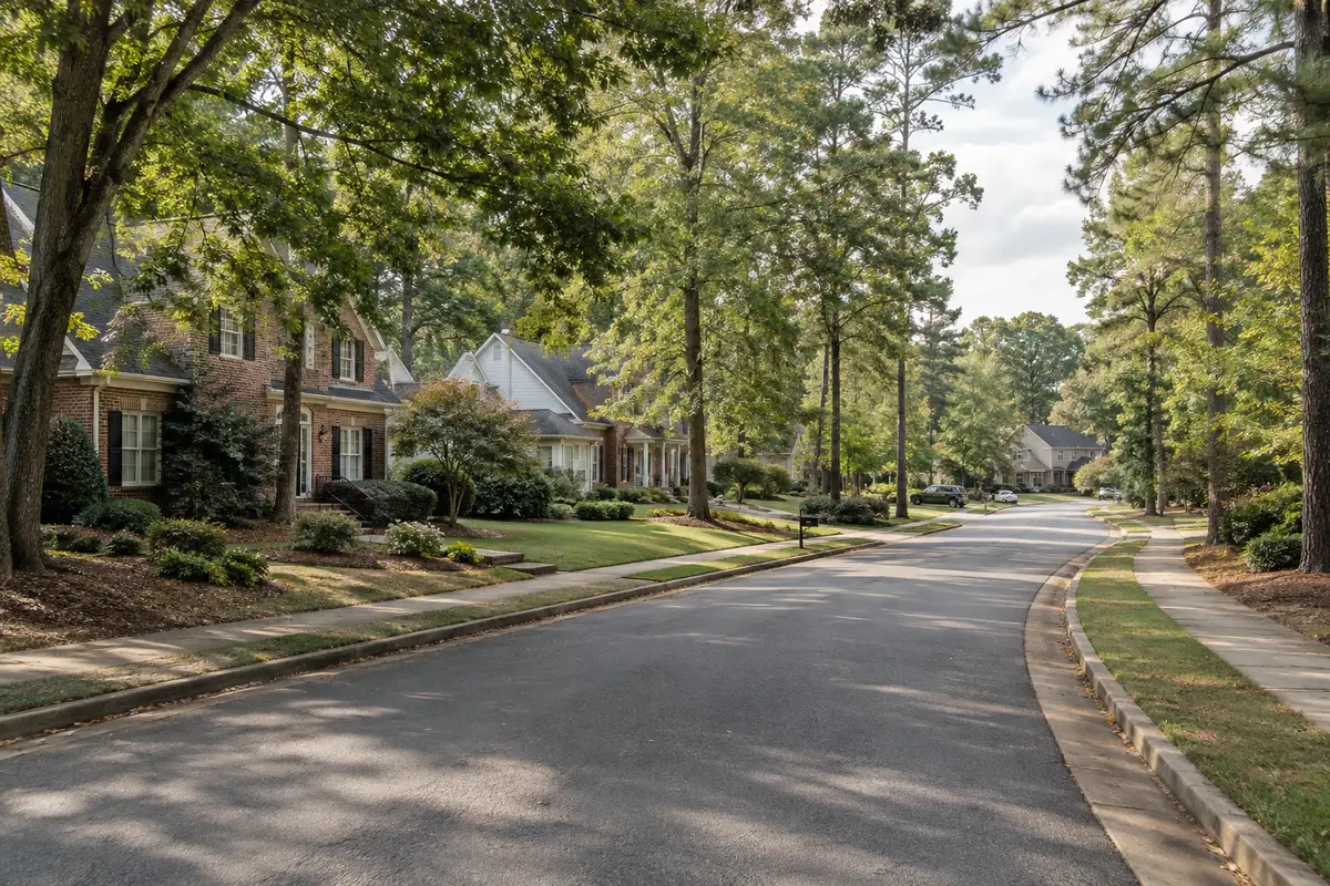 Quiet suburban street with mature trees and varied home styles